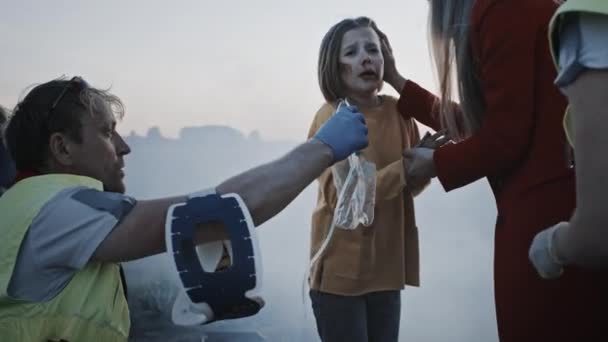 Paramédicos dando máscaras de oxigênio de primeiros socorros para uma jovem vítima do acidente. Profissionais salvando vidas. Fumar em todo o lado — Vídeo de Stock