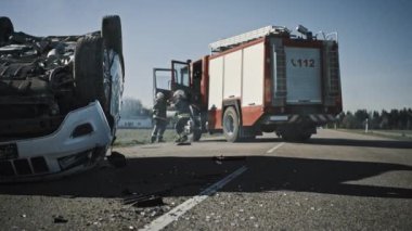 İtfaiyecilerden oluşan kurtarma ekibi çarpışmaya, felakete, itfaiye istasyonuna ulaştı. İtfaiyeciler ekipmanlarını alın, yangın hortumlarını ve teçhizatı itfaiye aracından hazırlayın, yaralılara yardım etmek için acele edin..