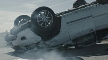 Korkunç Trafik Kazası Sigara İçen ve Yanan Araç Çarpışmadan Sonra Yolun Ortasında Çatısında Yatıyor. Hasarlı Arabalı Gündüz Çarpışması. Düşük Açı Düşük Karşıtlık Vuruşu