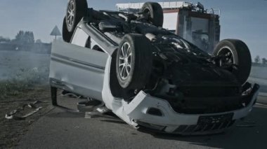 Korkunç trafik kazası rollover sigara ve yanan araç çarpışma sonrası yolun ortasında çatısında yatıyor. Firefighters ve yangın motoru kamyon arka plan ekibi. Siyah ve beyaz shot