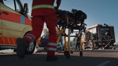 Trafik Kazası Olay Yeri İnceleme Ekibi: Ambulans ve İtfaiyeciler Kurtarma Ekibi, Rollover Aracında Tuzağa Düşenleri Kurtardı. Profesyoneller kurbanları temizler, ilk yardımı yapar, yangını söndürür.