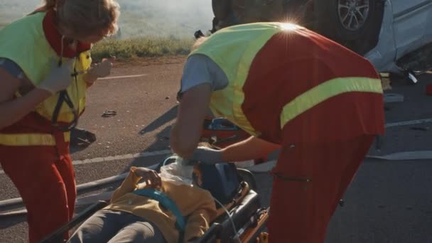 Op de auto crash verkeersongeval scene: paramedics redden van het leven van een klein meisje liggend op brancards, ze heeft de beste eerste hulp hulp. Professionele Medics die hun werk het beste doen — Stockvideo