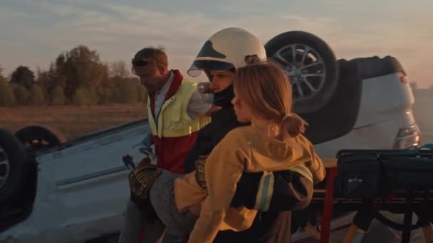 Dzielny Strażak Niesie Rannych Młoda Dziewczyna Bezpieczeństwa Tle Samochód Crash — Wideo stockowe