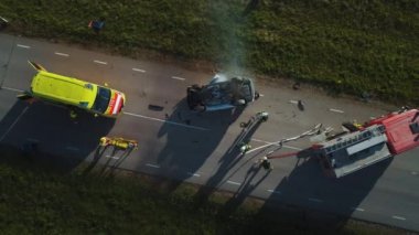 Havadan görünüm: Firefighters ve Paramedi kurtarma ekibi bir araba kazasında trafik kaza sahnesinde çalışır. Ekipman hazırlama, Ilk yardım yardımı. Yaralı ve kapana kısılmış ınsanları araçtan kurtarmak. Yakınlaştır
