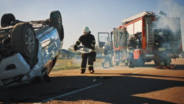 Equipo de Rescate de Bomberos Llegar a la escena de accidente de tráfico de choque de coches en su motor de bomberos. Los bomberos agarran sus herramientas, equipo y equipo de camión de bomberos, prisa para ayudar a las personas heridas, atrapados — Vídeos de Stock