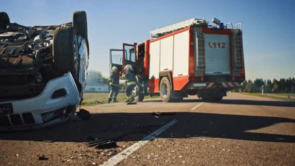 Einsatzkräfte der Feuerwehr treffen mit ihrem Löschfahrzeug am Unfallort ein. Feuerwehrleute holen Werkzeug, Ausrüstung und Ausrüstung aus Feuerwehrauto, eilen zu Verletzten, Verschütteten — Stockvideo