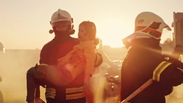 Bombeiro corajoso leva menina ferida para a segurança. No acidente de carro de fundo acidente de trânsito com paramédicos corajosos e bombeiros salvar vidas, fogo de combate — Vídeo de Stock