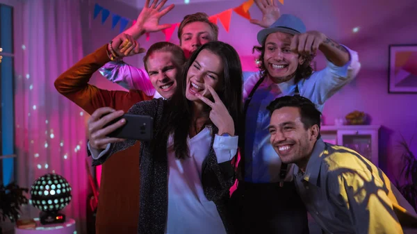 Ευτυχισμένη ομάδα νέων ανθρώπων που παίρνουν συλλογική selfie στο κόμμα Wild House. Φώτα νέον, ντίσκο μπάλα και αστεία κοστούμια. — Φωτογραφία Αρχείου