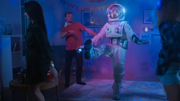 A főiskola ház jelmez party: szórakozás Guy viselése térben öltöny táncok ki, ennek robot tánc modern mozgatja. Vele gyönyörű lányok és fiúk tánc neonfények. — Stock Fotó