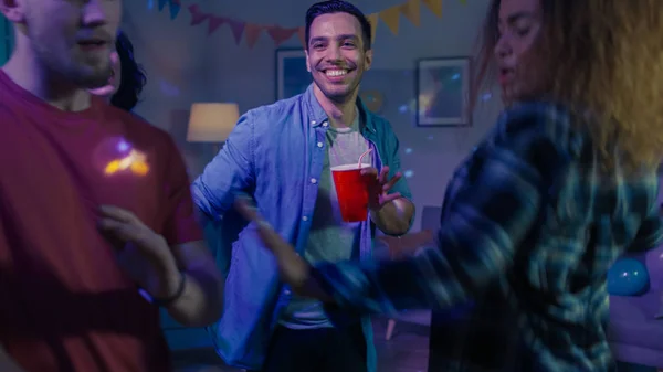 At the College House Party: Stylish Boys and Girls Dances in the Living Room. Diverse Group of Friends Have Fun, Dancing and Socializing. Disco Neon Strobe Lights Illuminating Room. — Stock Photo, Image