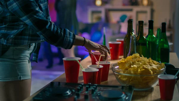 No College House Party: Girl Takes Glass with Drink from the Tray. Diversos grupos de amigos se divertem, dançam e socializam. Disco Neon Strobe Lights Iluminando Quarto . — Fotografia de Stock