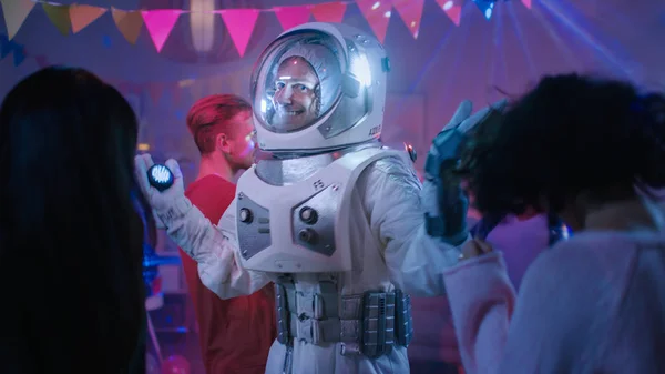 At the College House Costume Party: Fun Guy Wearing Space Suit Dances Off, Doing Robot Dance Modern Moves. With Him Beautiful Girls and Boys Dancing in Neon Lights. — Stock Photo, Image