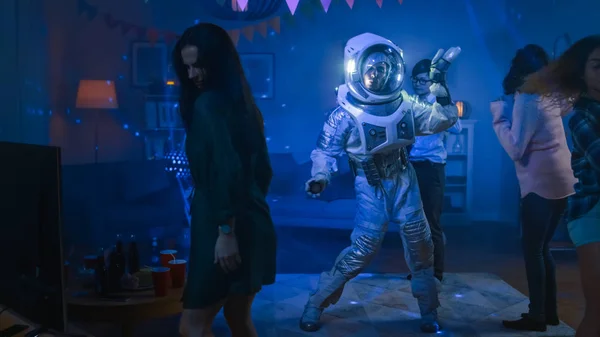 Kolej Evi kostüm partisi: eğlenceli adam giyim uzay Suit dans, robot dansı modern Moves Doing. Onu güzel kızlar ve çocuklar Neon ışıklar dans ile. — Stok fotoğraf