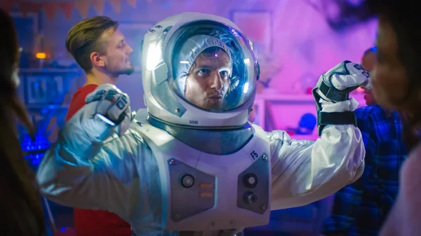 At the College House Costume Party: Fun Guy Wearing Space Suit Dances Off, Doing Robot Dance Modern Moves. With Him Beautiful Girls and Boys Dancing in Neon Lights. — Stock Photo, Image