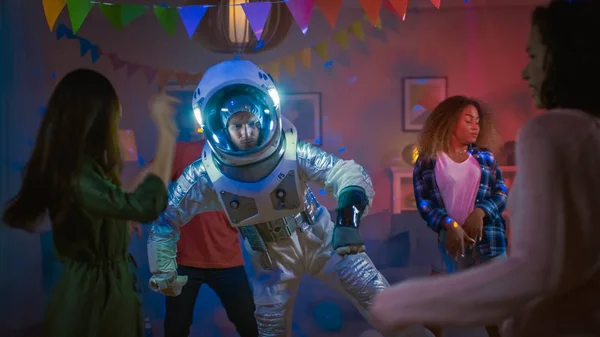 At the College House Costume Party: Fun Guy Wearing Space Suit Dances Off, Doing Robot Dance Modern Moves. With Him Beautiful Girls and Boys Dancing in Neon Lights. — Stock Photo, Image