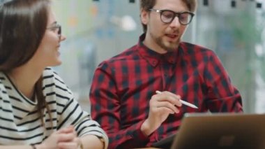 Genç kadın ve Iki erkek meslektaşları dostça bir toplantıya sahip ve yeni Iş fikirleri tartışıyor. Loft ofis Creative Agency easygidiş coworking atmosfer. Onlar başarılı bir çözüm kutlamak.