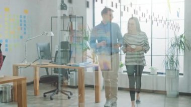 Genç kadın ve Man meslektaşları ofiste yürüyüş yeni Iş fikirleri hakkında dostça bir tartışma yaşıyorsanız. Creative Agency 'de kolay çalışan bir atmosfer.