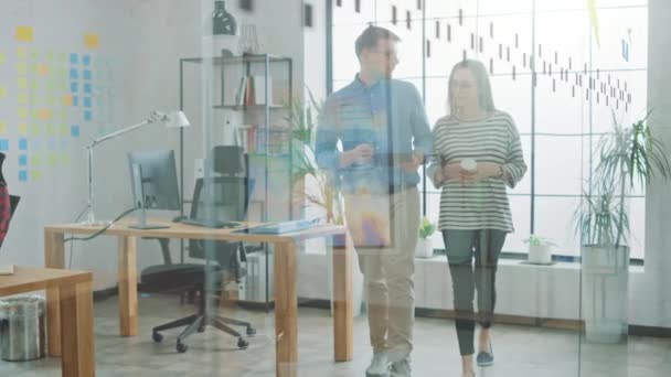 Jeunes femmes et hommes collègues marchant dans le bureau tout en ayant une discussion amicale sur les nouvelles idées d'affaires. Atmosphère de Coworking Easygoing dans l'Agence Créative .