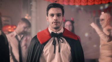 Cadılar Bayramı Kostüm partisi: Kont Dracula portre sırıtmaya, onun ölümcül Bloody fangs gösterir. Arka planda Retro yaktı, korkunç canavarlar dans ile dekore edilmiş Oda