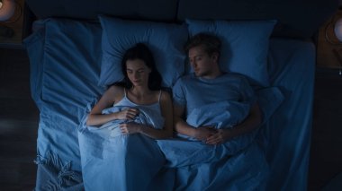 Sevimli Genç çift tatlı yatakta uyuyan. Koyu rahat oda.