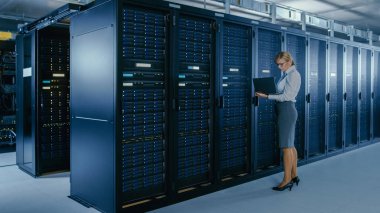 Veri merkezi 'nde: bir laptop üzerinde bakım programı çalışan kadın BT teknisyeni, operasyonel sunucu raf optimum Işleyişini kontrol eder. Modern High-Tech telekomünikasyon operasyonel veri merkezi.