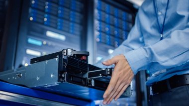 Modern veri merkezi: BT mühendisi yeni HDD sabit disk ve diğer donanım sunucu raf ekipmanları içine yükler. Bakım yapan, tanılama çalıştıran ve donanım güncellemesi yapan uzman.