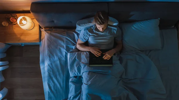 Top View Young Man in Bed Lucrând la un laptop pe timp de noapte Studentul se pregătește de examene, managerul de proiect dedicat excepțional finalizând lucrul în pat noaptea . — Fotografie, imagine de stoc