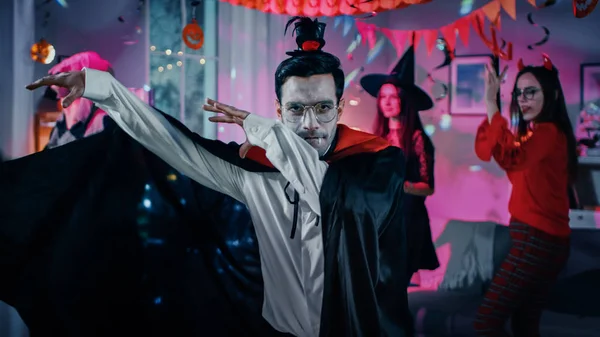 Halloween Monster Costume Party : Vampire comte Dracula portant son cap fait danse drôle, En arrière-plan Belle sorcière, magnifique elle diable et effrayant mort dansant dans la chambre décorée — Photo