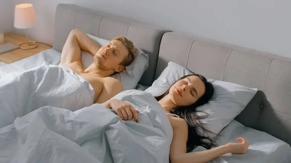 Na manhã bonito jovem casal dormindo Cozily na cama. Jovens apaixonados. De manhã cedo sol brilha através da janela . — Fotografia de Stock
