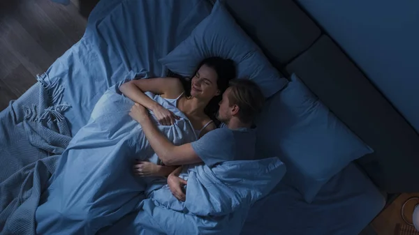 Cute Młoda para Sweetly spanie w łóżku, mężczyźni Tenderly przytulanie i obejmując jej uśmiechnięta dziewczyna podczas Dreaming. Pokój ciemny przytulny. — Zdjęcie stockowe