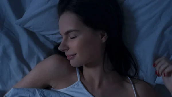 Portretul frumoasei tinere brunete care doarme fermecător în patul ei în primele ore ale dimineții. Vedere dulce și caldă a fetei care doarme calm. Top Down Shot . — Fotografie, imagine de stoc