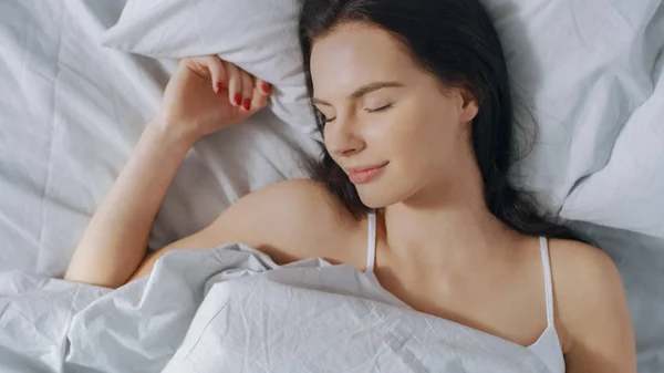 Retrato de una hermosa morena usando un teléfono inteligente con pantalla táctil en su cama, charlando con amigos, usando las redes sociales, publicando imágenes, compartiendo pensamientos. Top Down Shot . —  Fotos de Stock