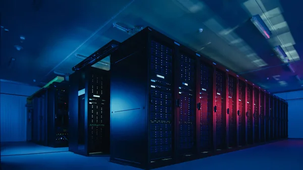 Shot van Data Center met meerdere rijen van volledig operationele server racks. Moderne telecommunicatie, Cloud Computing, kunstmatige intelligentie, database, supercomputer technologie concept. Geschoten in het donker met neon blauw, roze licht. — Stockfoto
