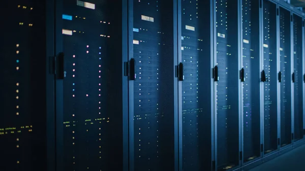 Shot van Dark Data Center met meerdere rijen van volledig operationele server racks. Moderne telecommunicatie, Cloud Computing, kunstmatige intelligentie, database, supercomputer. Blauwe neon licht. — Stockfoto