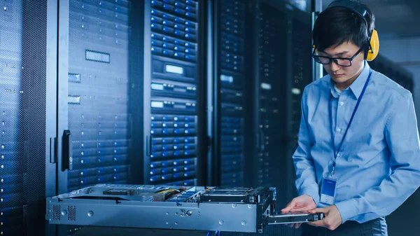 No Data Center Moderno: Técnico de TI Trabalhando com Racks de Servidor, em um Pushcart Instalando Novo Hardware. Engenheiro Fazendo Manutenção e Diagnóstico do Banco de Dados . — Fotografia de Stock