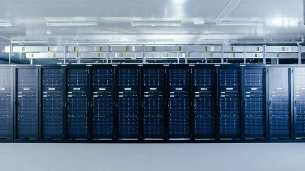 Colpo di un centro dati di lavoro con righe di server rack. Le luci principali lampeggiano e i computer funzionano . — Foto Stock