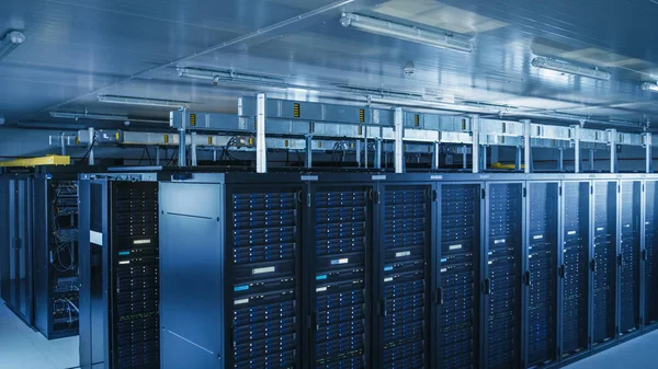 Absteigender Schuss eines modernen Rechenzentrums mit mehreren Reihen operativer Serverschränke. Moderne High-Tech-Datenbank Supercomputer Reinraum. — Stockfoto