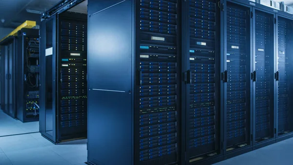 Snímek moderního datového centra s více řadami operačních stojanů serveru. Moderní high-tech databáze super počítač čistý pokoj. — Stock fotografie