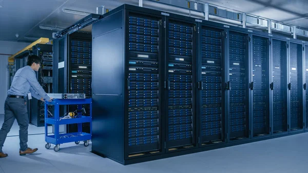 Di Pusat Data Modern: Tim Teknisi IT bekerja sama dengan Server Racks, Menjalankan Pemeliharaan dan Diagnostik, Memeriksa Jaringan dan Cloud Computing Optimal Functioning . — Stok Foto