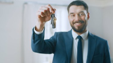 Bir takım elbise Smiles ve teklifler anahtarları yeni bir daire başarılı Emlak ajanı. Yenilenmiş olmak Oda ortasında ayakta. Profesyonel gayrimenkul broker tarafından Satılık geniş yeni ev.