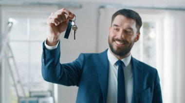 Bir takım elbise Smiles ve teklifler anahtarları yeni bir daire başarılı Emlak ajanı. Yenilenmiş olmak Oda ortasında ayakta. Profesyonel gayrimenkul broker tarafından Satılık geniş yeni ev.