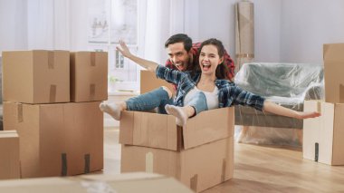 Genç çift Moving Into yeni daire, erkek arkadaşı sürücüler kız arkadaşı karton kutu, o uçak Wings taklit eder. Genç erkek arkadaşı ve kız arkadaşı birlikte yaşamaya başlayın, şeyler açmak, eğlenmek.