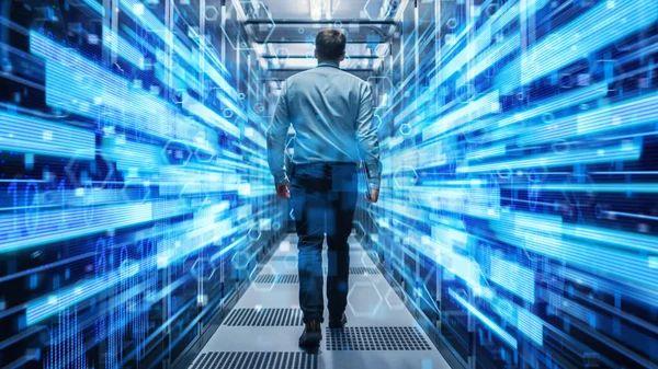 Shot van een jonge IT-specialist die door de gang loopt in een werkend Data Center vol rack servers en supercomputers. Conceptuele visualisatie van hoge snelheid Internet verbinding met cijfers en lijnen. — Stockfoto