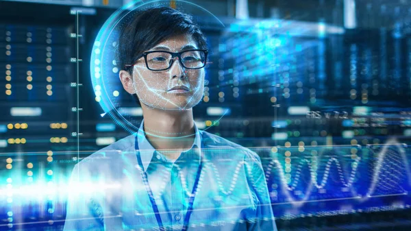 Young Asian IT Engineer Identified by Biometric Facial Recognition Scanning Process in Data Center Server Room. Futuristic Concept: Projector Identifies Individual by Illuminating Face by Lines.