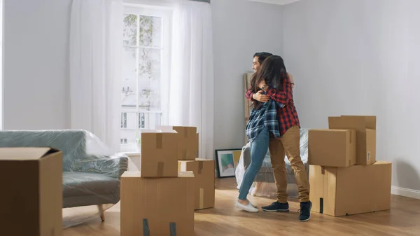 Joyeux jeune couple emménageant dans un nouvel appartement, portant du carton — Photo