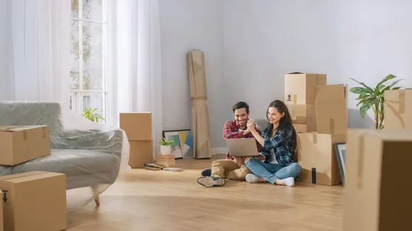 Pareja joven y feliz sentada en el piso de recién alquilado / comprado — Foto de Stock