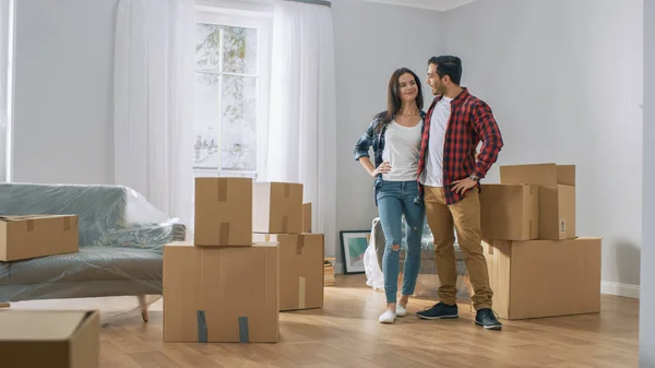 Happy Young Couple Moving Into New Apartment, Carrying Cardboard