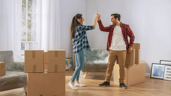 Joyeux jeune couple emménageant dans un nouvel appartement, porteur de cardbo — Photo