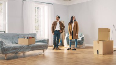 Mutlu ve heyecanlı genç çift bakmak Around Içinde Wonder onların yeni satın alınan/kiralık daire. Güzel Insanlar mutlu Poses. Büyük parlak modern ev karton kutular hazır açmak için.