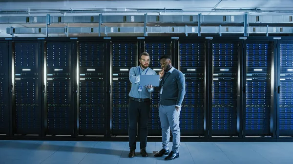 Bearded IT Technician in Glasses with a Laptop Computer and Blac